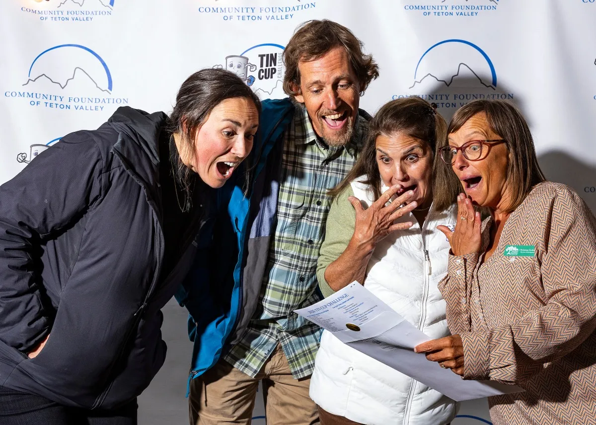 Four excited donors reacting to their Tin Cup Challenge award at the Community Foundation photo booth