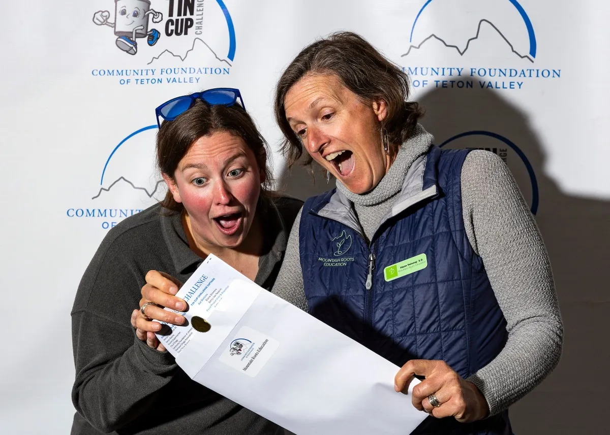 Two Tin Cup Challengers excitedly reading their challenge certificate at the Community Foundation event